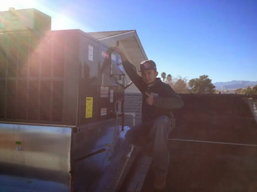 HVAC technician performing Boiler Repair on a rooftop unit in Newport Beach
